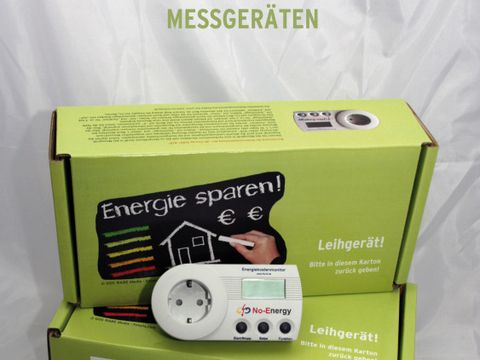 Zwei grüne Pappkartons, davor Steckdose und Kabel