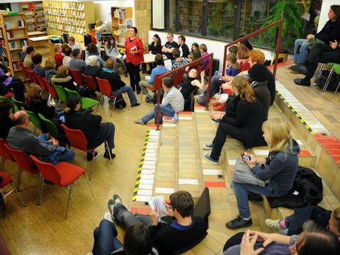 Mehrere Menschen hören Frau Zimmermann zu