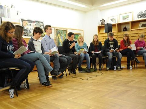 Jugendliche sitzen im Stuhlkreis und hören zu
