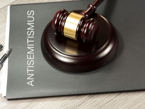 ein Justiziar-Hammer liegt auf einer Mappe mit Aufschrift Antisemitismus