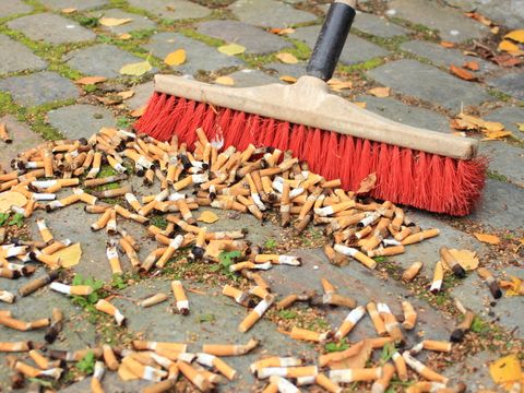 Viele Zigarettenkippen von Stein Straße fegen