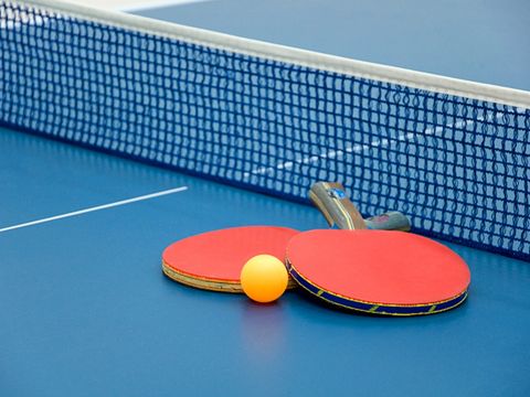 Zwei Tischtenniskellen auf einer blauen Tischtennisplatte