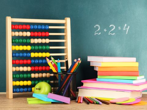Spielzeug Abakus, Bücher und Stifte auf Tisch, mit der Schule-Schreibtisch-Hintergrund