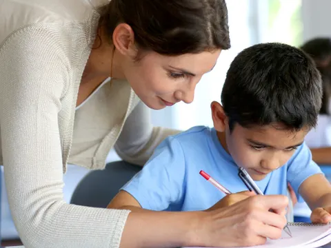 Lehrerin hilft kleinem Jungen bei den Hausaufgaben