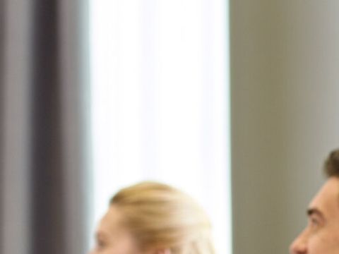 Drei lächelnde Geschäftsleute sitzen im Büro