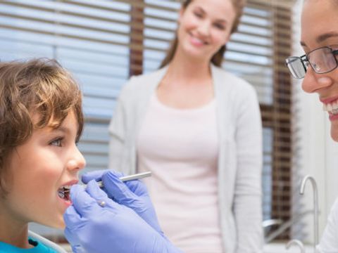 Zahnärztin untersucht kleinen Jungen
