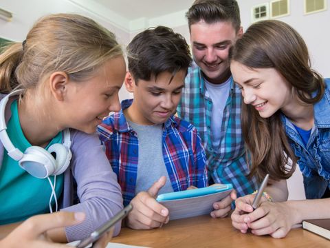 junge Schüler schauen auf ein Tablet