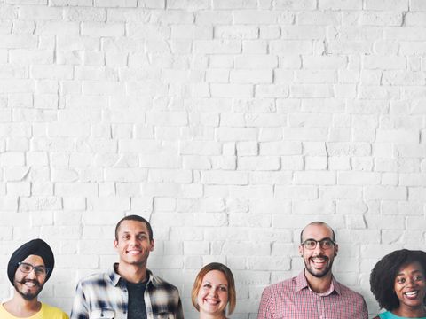Diverse Menschen stehen nahe Mauer