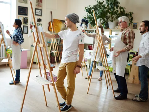 eine Gruppe Menschen mit einer Leinwand in einem Atelier