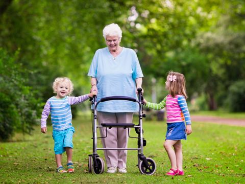 Oma mit Rollator und zwei kleinen Kindern im Park