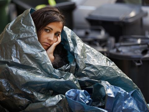 Obdachlose junge Frau umwickelt mit Plastikplanen bei kaltem Wetter
