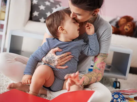 Junge Mutter spielt mit ihrem Baby