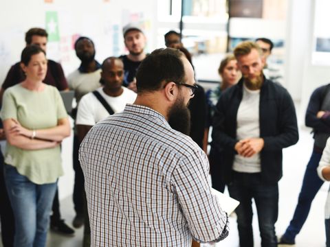 verschiedene Menschen hören einem Redner zu