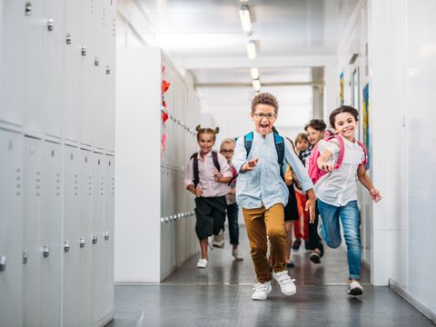 Schülerinnen und Schüler rennen über den Schulflur