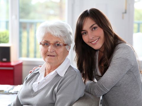 ältere Dame sitzt, hinter ihr steht eine junge Frau