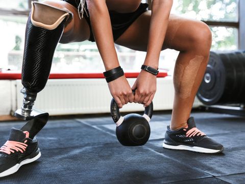 Mann mit Beinprothese hebt Gewichte im Fitnessstudio