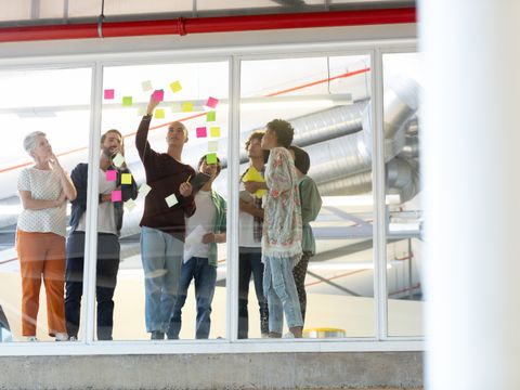 Menschen verschiedenen Alters brainstormen mit Klebezetteln