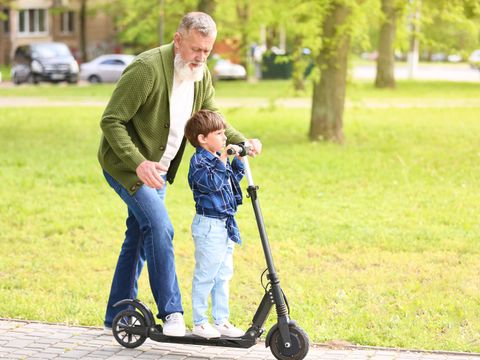 Opa und Enkel auf einem E-Scooter