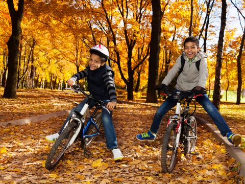 zwei Jungs auf Fahrrädern im Herbstwald