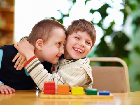 ein kleiner Junge umarmt seinen Spielkameraden