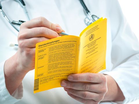 Arzt mit Impfpass in der Hand