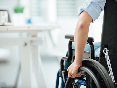 Frau im Rollstuhl von hinten betrachtet