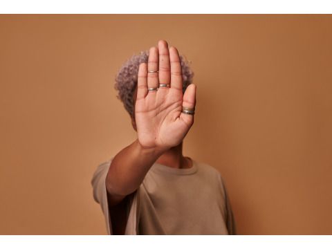 Person of Colour streckt ihre Handfläche nach vorne