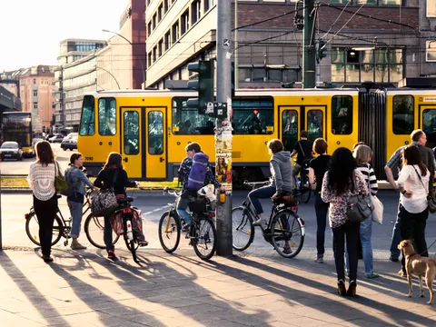 Fußgänger und Fahrradfahrer warten an Ampel