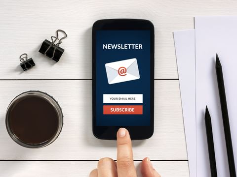 Abonnieren Sie Newsletter Konzept auf Smartphone-Bildschirm mit Office-Objekte
