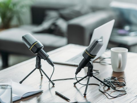 Zwei Tischmikrofone auf Tisch mit Laptop und Tasse
