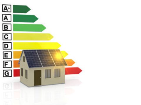 Energie-Effizienz-Maßstab hinter einem Haus mit einer Photovoltarikanlage