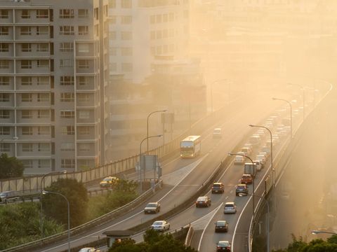 Luftverschmutzungsszene mit Autos auf der Autobahn und gelbem Rauch in der Stadt