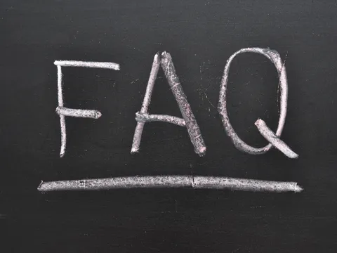Mit Kreide geschriebene Abkürzung FAQ auf einer schwarzen Tafel