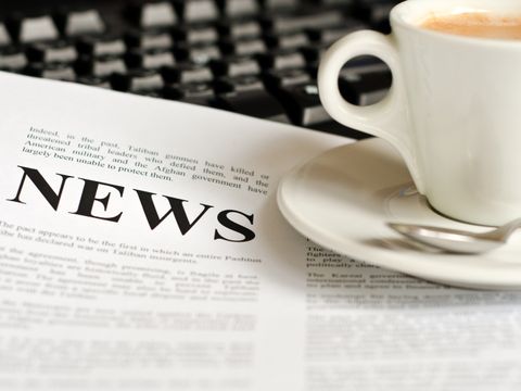 Kaffeetasse steht auf einer Tageszeitung