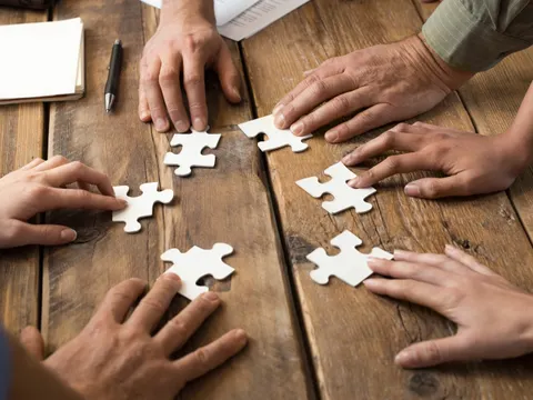 Hände Puzzelteile Tisch
