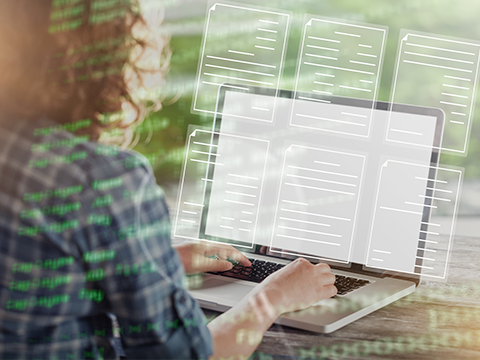 Frau vor dem Laptop mit mehreren digitalen Dokumenten