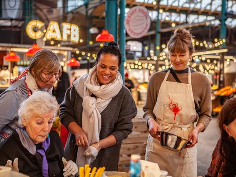 Frauen in der Markthalle Neun die gemeinsam gemeinsam Essen zubereiten