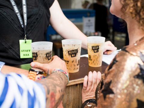 Ein Tresen mit drei gefüllten Bechern; die Becher haben die Aufschrift "Reuse me" und "Keep me"