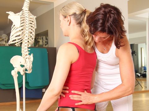 Physiotherapeutin mit Patientin an Lendenwirbelsäule