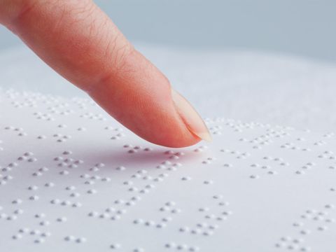 Zeigefinger fährt über Brailleschrift