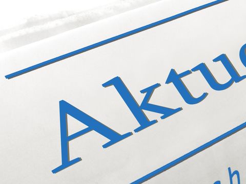 Zusammengerollte Zeitung; auf der Vorderseite steht mit großer Schrift "Aktuelles"