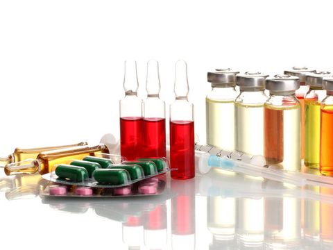 Ampullen, Spritzen und Tabletten liegen auf einem Tisch