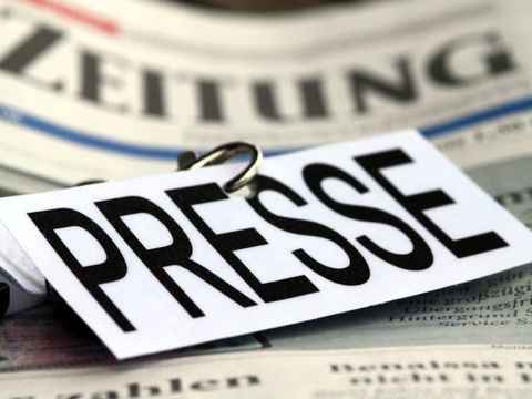 Ein Schild mit der Aufschrift "Presse" liegt auf einer Tageszeitung