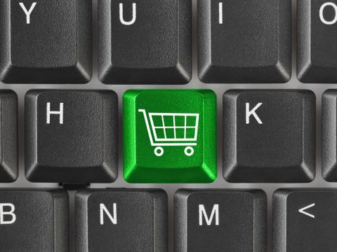 Computertastatur mit grünem Einkaufswagen