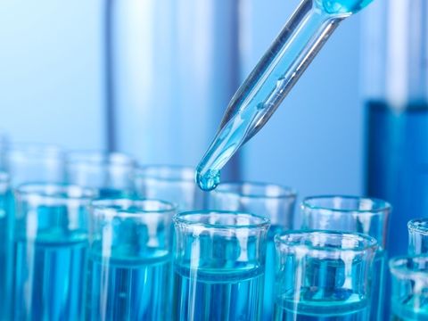 Flüssigkeit, die mit einer Pipette in mehrere Reagenzgläser gefüllt wird