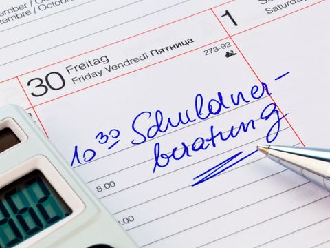 Kalendereintrag "10:30 Uhr Schuldnerberatung". Daneben ist zum Teil ein Taschenrechner und ein Kugelschreiber zu sehen.