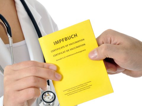 Patient übergibt Impfpass an Arzt