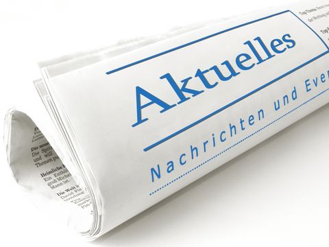 Zusammengerollte Zeitung; auf der Vorderseite steht mit großer Schrift "Aktuelles"