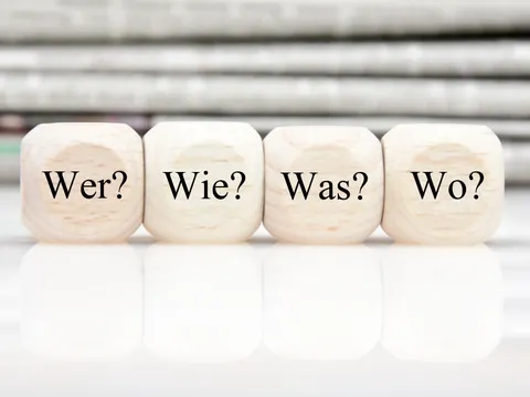 Vier Würfel mit den Fragen Wer? Wie? Was? Wo?