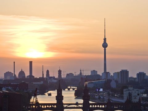 Die Silhouette der Oberbaumbrücke in der Abenddämmerung; im Hintergrund der Fernsehturm